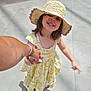 child, girl, smiling, hat, straw_hat, yellow_dress, holding_hands, sunlight, shadow, indoor, tile_floor, footwear, sandal, happy, portrait, person, cute, summer, fashion, hand