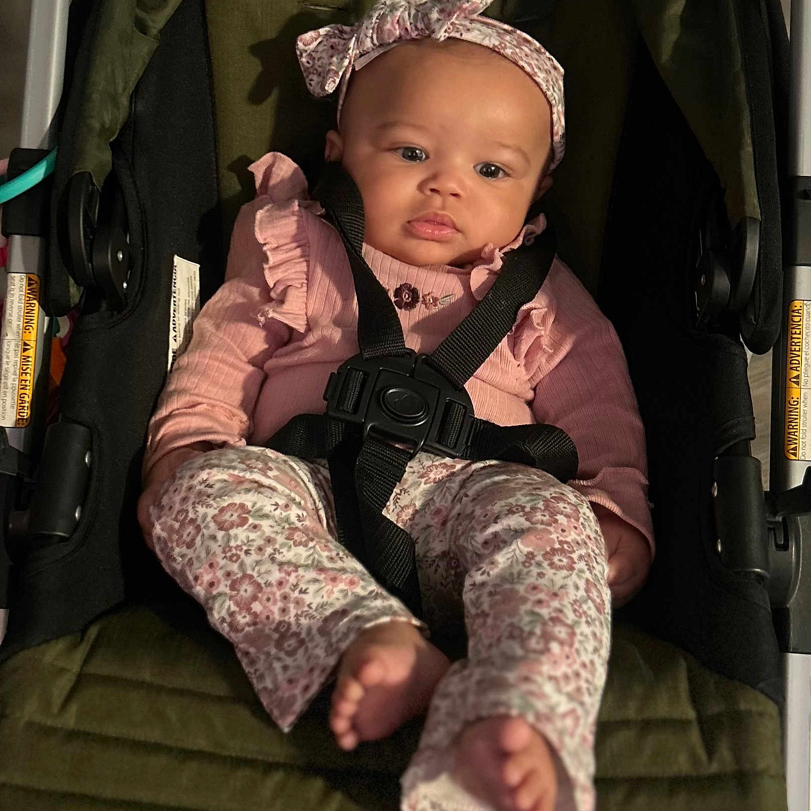 Dominique is registered to the contest to win money with this photo: baby, baby_girl, bow, car_seat, child, clothing, comfort, cute, floral_pattern, footwear, headband, indoor, infant, person, pink_clothing, portrait, safety, seatbelt, sitting, young_child