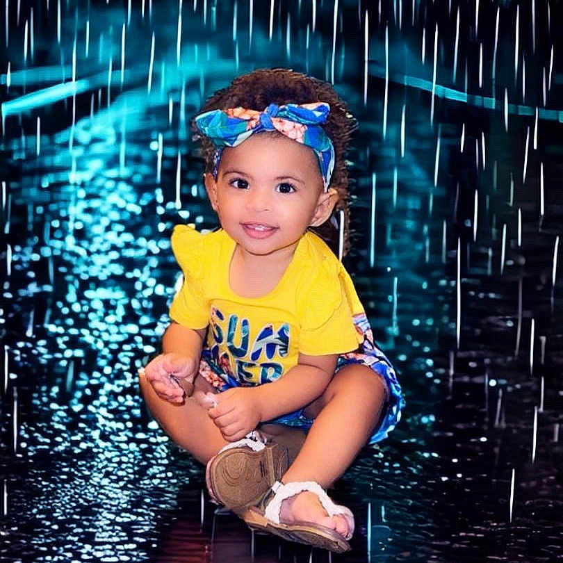 Lakitta is registered to the contest to win money with this photo: accessories, child, clothing, face, female, footwear, girl, glasses, head, lighting, nature, outdoors, person, photography, portrait, shoe, shorts, sitting, t_shirt, water