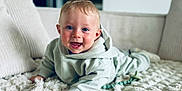 Mael a rejoint le concours — aidez-le/la à gagner de superbes lots ! baby, child, hoodie, blue_eyes, smiling, lying_down, fluffy_rug, cushions, indoor, home, cute, happy, person, infant, portrait, soft_lighting, cozy, casual_clothing, toddler, baby_toy