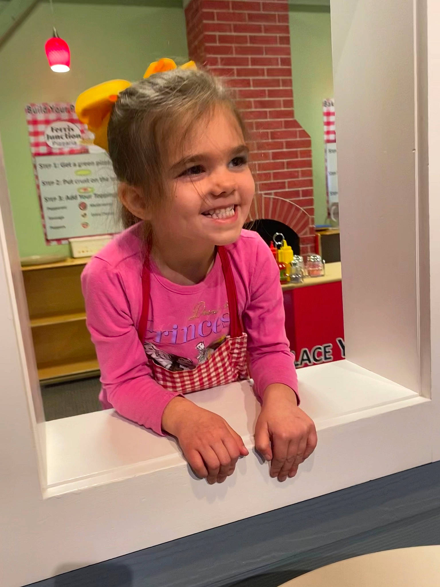 Jaelynn is registered to the contest to win money with this photo: child, finger, fun, gesture, happy, joy, magenta, nail, person, pink, play, room, sleeve, smile, t_shirt, thumb, toddler, window
