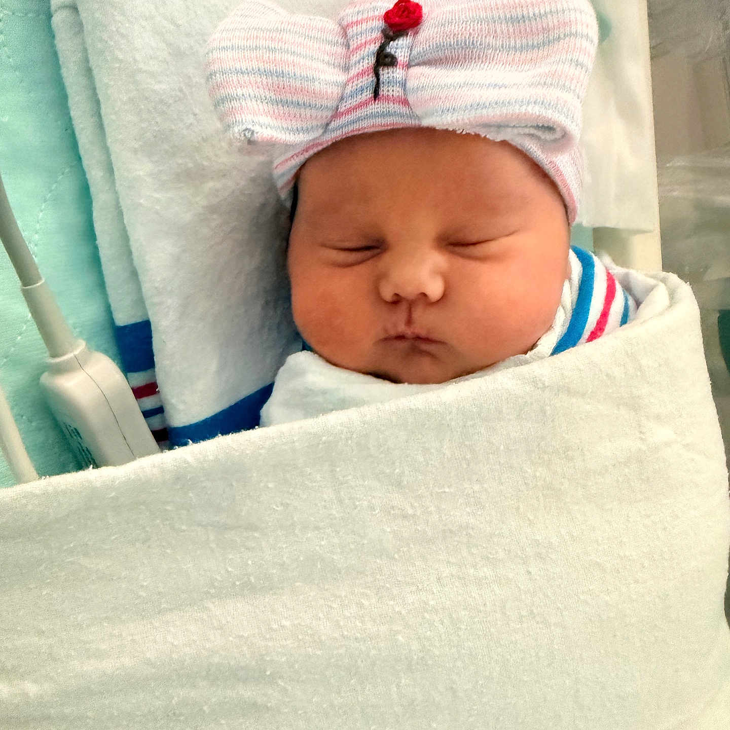 Evelyn is registered to the contest to win money with this photo: newborn, baby, infant, sleeping, portrait, face, hospital, blanket, swaddled, hat, bow, striped, indoors, bedding, peaceful, closed_eyes, nursery, medical_equipment, photography, resting