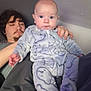 Tristan is registered to the contest to win money with this photo: baby, infant, person, indoor, onesie, clothing, relaxing, lap, blue, patterned, face, head, sleepy, young, cozy, casual, human, room, blanket, comfort