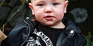 Tristan joined the competition — help win amazing prizes! baby, child, leather_jacket, black_clothing, blue_eyes, jeans, flower, graffiti, outdoor, portrait, cute, fashion, casual, person, young_child, sitting, punk_style, tshirt, closeup, urban