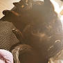 cat, black_cat, pet, indoor, sunlight, relaxed, lying_down, paw, fur, cozy, knitted_fabric, cushion, window_light, home, feline, cute, playful, resting, soft_light, animal