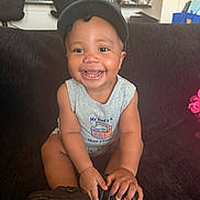 Savyon joined the competition — help win amazing prizes! baby, toddler, smiling, cap, sleeveless_shirt, indoor, couch, child, happy, person, furniture, kitchen, household, seated, cute, portrait, young_child, bright, expression, casual