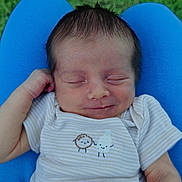 Benicio Winter is registered to the contest to win money with this photo: baby, newborn, infant, sleeping, onesie, blue_cushion, grass, peaceful, smile, cute, child, portrait, outdoor, happy, clothing, hand, head, face, skin, resting