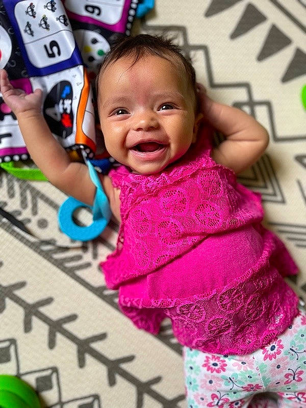 Ebony is registered to the contest to win money with this photo: baby_toddler_clothing, child, event, facial_expression, fun, green, happy, joy, leisure, magenta, pattern, people, person, pink, play, purple, sleeve, smile, snapshot, textile
