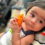 Monroe is registered to the contest to win money with this photo: baby, child, plush_toy, hand, face, eyes, blanket, soft_toy, infant, cute, portrait, indoors, clothing, polka_dot, skin, expression, lying_down, closeup, young_child, resting