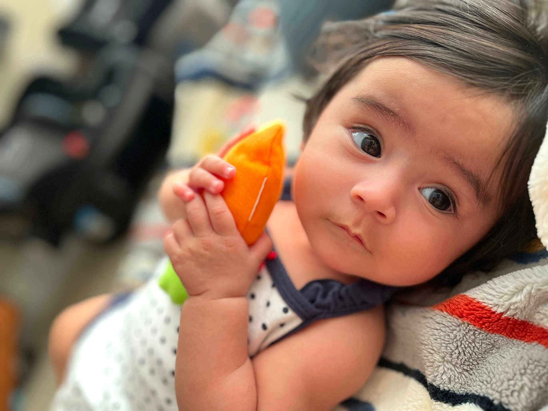 Monroe is registered to the contest to win money with this photo: baby, child, plush_toy, hand, face, eyes, blanket, soft_toy, infant, cute, portrait, indoors, clothing, polka_dot, skin, expression, lying_down, closeup, young_child, resting