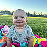 baby, smiling, outdoor, grass, blanket, onesie, child, happy, cute, nature, sunset, field, colorful, infant, portrait, sky, sitting, face, person, playtime