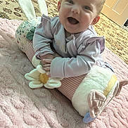 Lylah is registered to the contest to win money with this photo: baby, child, smiling, happy, indoors, plush_toy, bunny_ears, blanket, carpet, pajamas, soft_toy, floor, head, face, person, cute, infant, cozy, toddler, playful