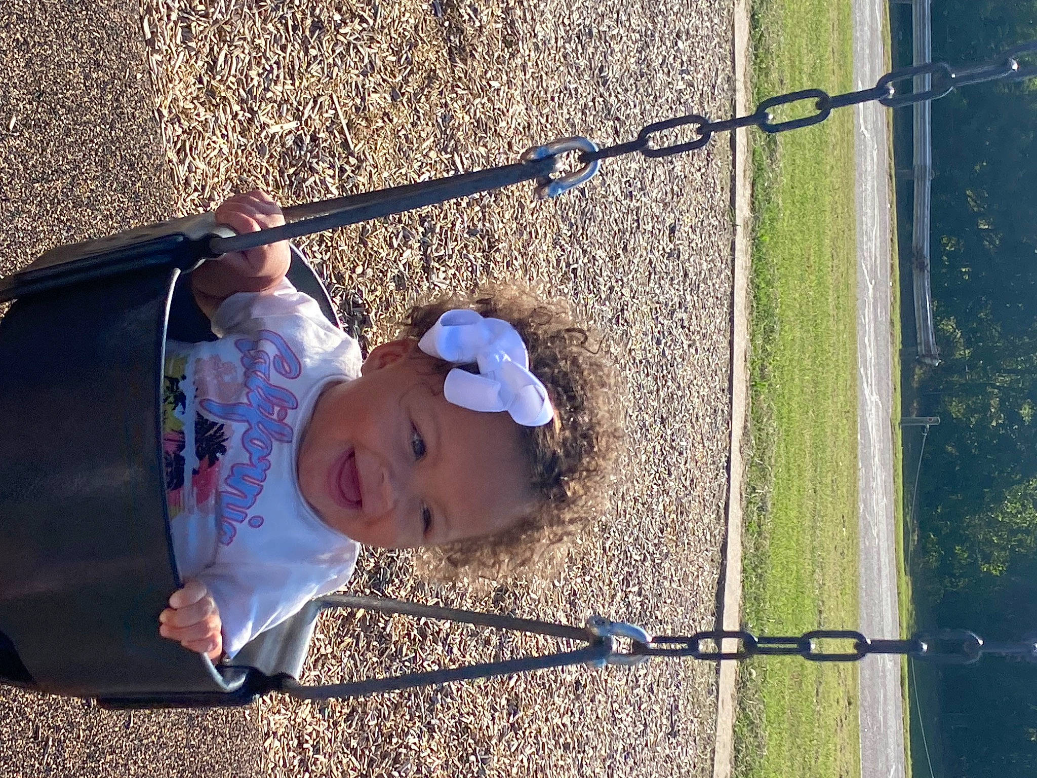 Avionna is registered to the contest to win money with this photo: baby, cap, chain_link_fencing, child, city, fun, grass, happy, hat, leaf, leisure, mesh, people_in_nature, person, recreation, shade, sun_hat, sunlight, tints_and_shades, toddler