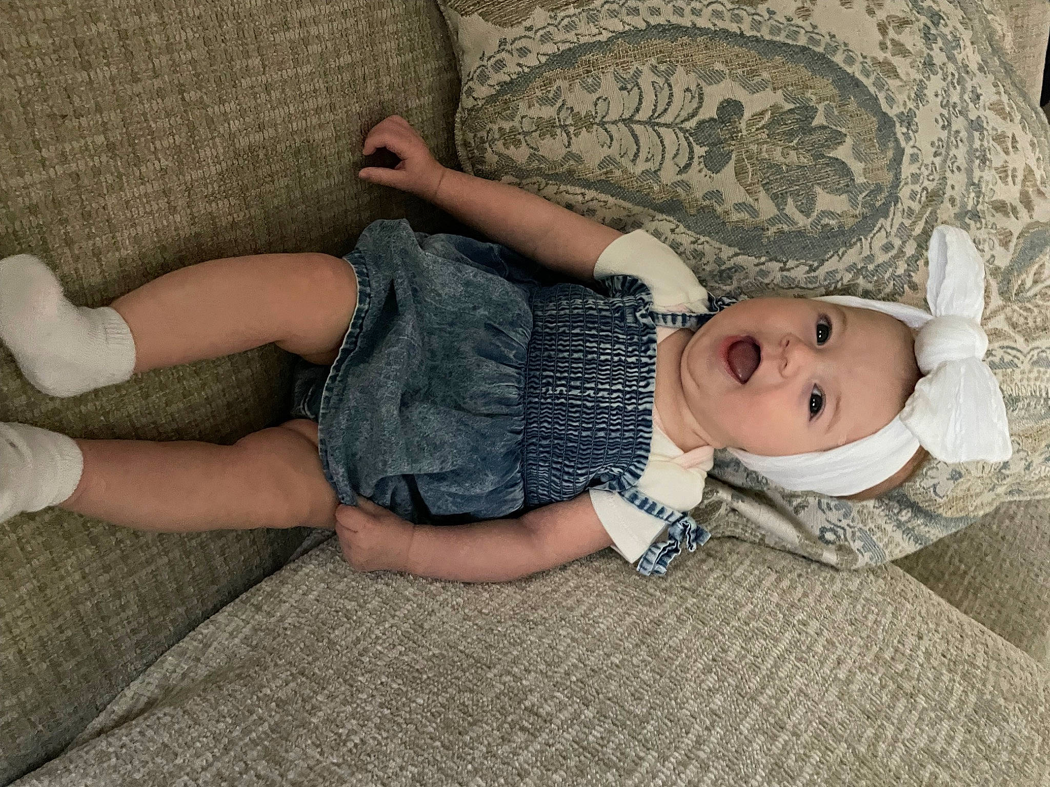 Anika is registered to the contest to win money with this photo: baby_toddler_clothing, child, comfort, finger, flooring, foot, grass, hat, headwear, human_body, human_leg, joint, knee, leg, linens, pattern, person, skin, sock, thigh