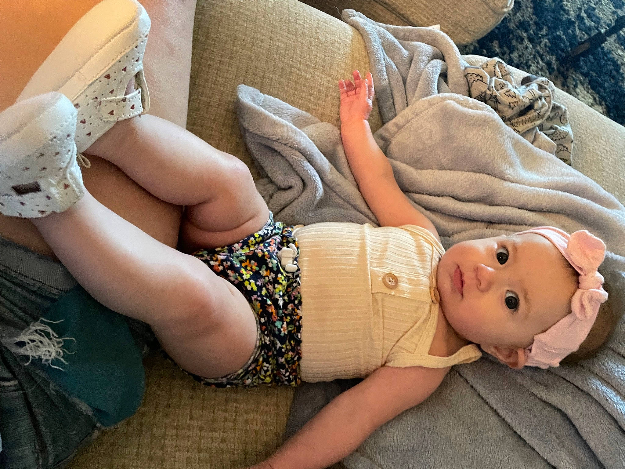 Anika is registered to the contest to win money with this photo: arm, baby, child, comfort, eyewear, finger, grass, hand, hat, headgear, headwear, human_body, human_leg, joint, knee, nail, person, skin, textile, thigh