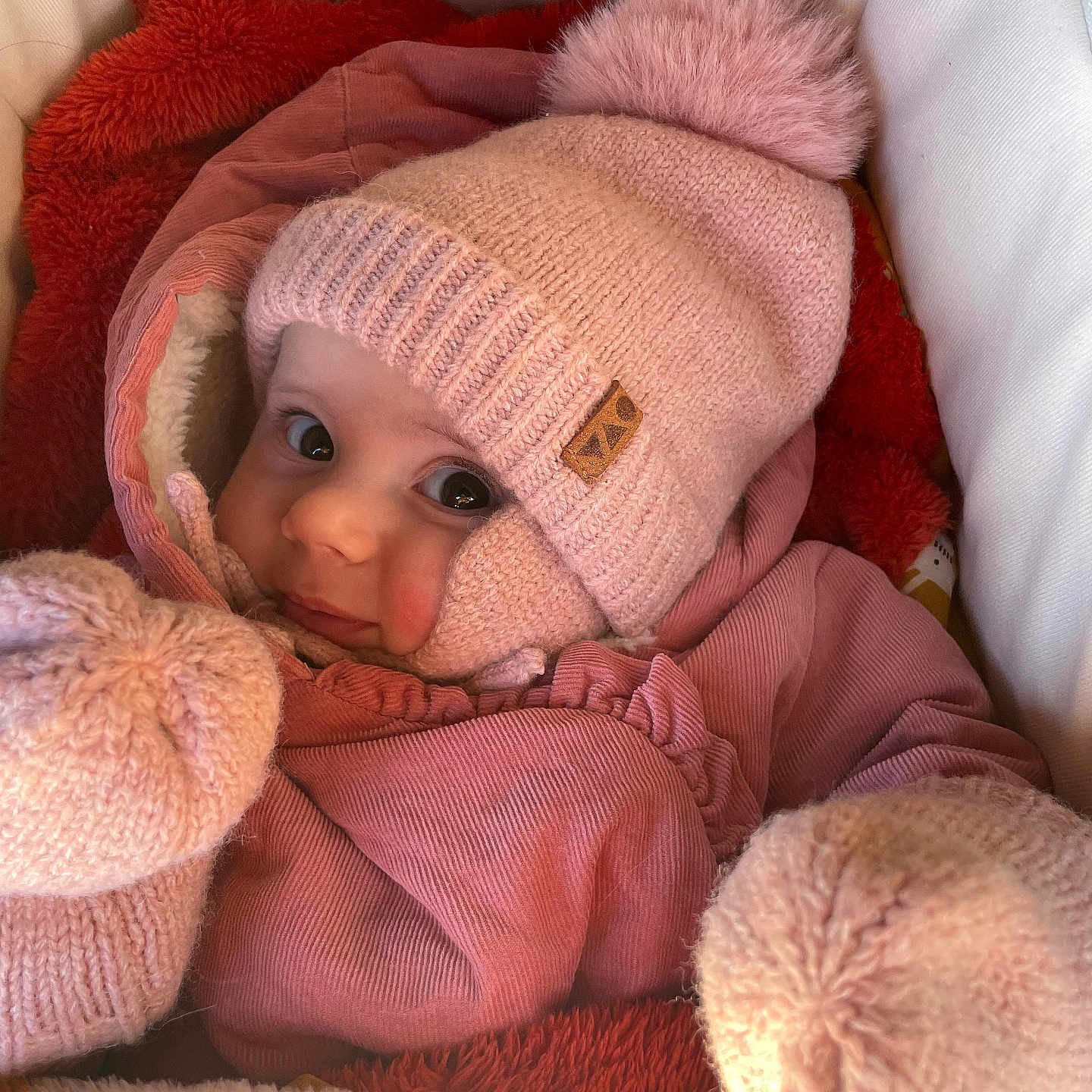 Léonie a rejoint le concours — aidez-le/la à gagner de superbes lots ! baby, baby_clothes, blanket, bundle, child, comfort, cozy, cute, face, indoor, infant, jacket, mittens, newborn, pink_hat, pom_pom, portrait, snug, soft_texture, warm_clothing