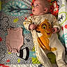 baby, infant, onesie, simba, lion_king, plush_toy, play_mat, colorful, animal_patterns, pink_onesie, child, cute, lying_down, soft_toys, cartoon_character, fabric, baby_clothes, baby_boy, indoor, portrait