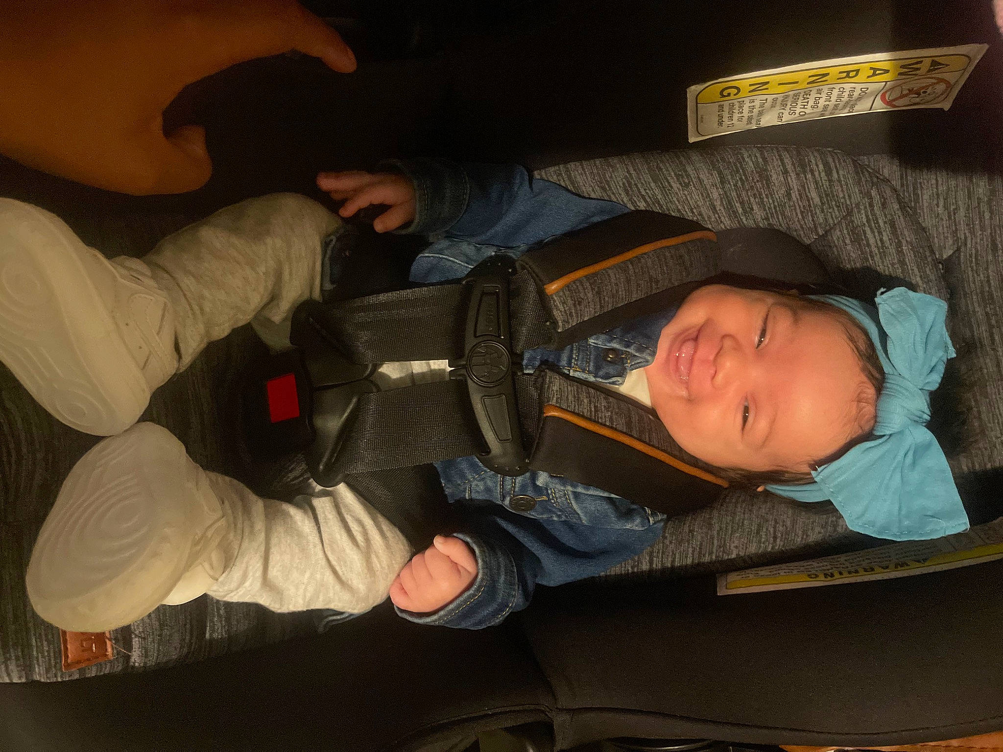 Ariya is registered to the contest to win money with this photo: auto_part, automotive_lighting, baby, car_seat, child, comfort, cool, elbow, finger, fun, gesture, headwear, human, joy, lap, mouth, person, sitting, space, thumb