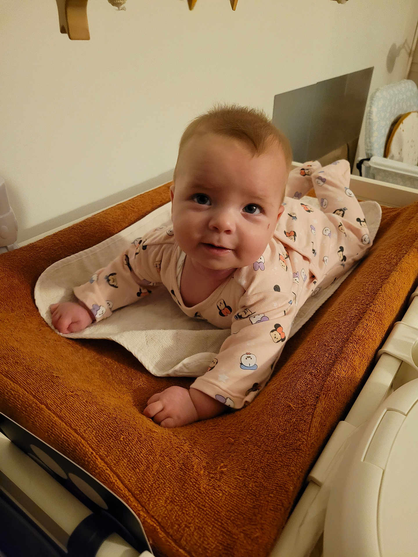 Maelia a rejoint le concours — aidez-le/la à gagner de superbes lots ! baby, infant, pajamas, cartoon_prints, changing_pad, brown, white, face, hands, indoor, home, cute, smile, child, person, soft_texture, furniture, bedroom, curious, skin