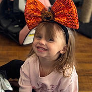 Lilianna joined the competition — help win amazing prizes! child, smile, happy, bow, headband, orange, pumpkin, halloween, indoor, floor, wooden_floor, clothing, pink_sweater, long_hair, person, cute, young, face, portrait, casual