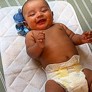 Ezekiel joined the competition — help win amazing prizes! baby, infant, smile, diaper, pacifier, mat, lying_down, happy, child, skin, hand, face, head, cute, indoors, striped, fabric, soft, newborn, toddler