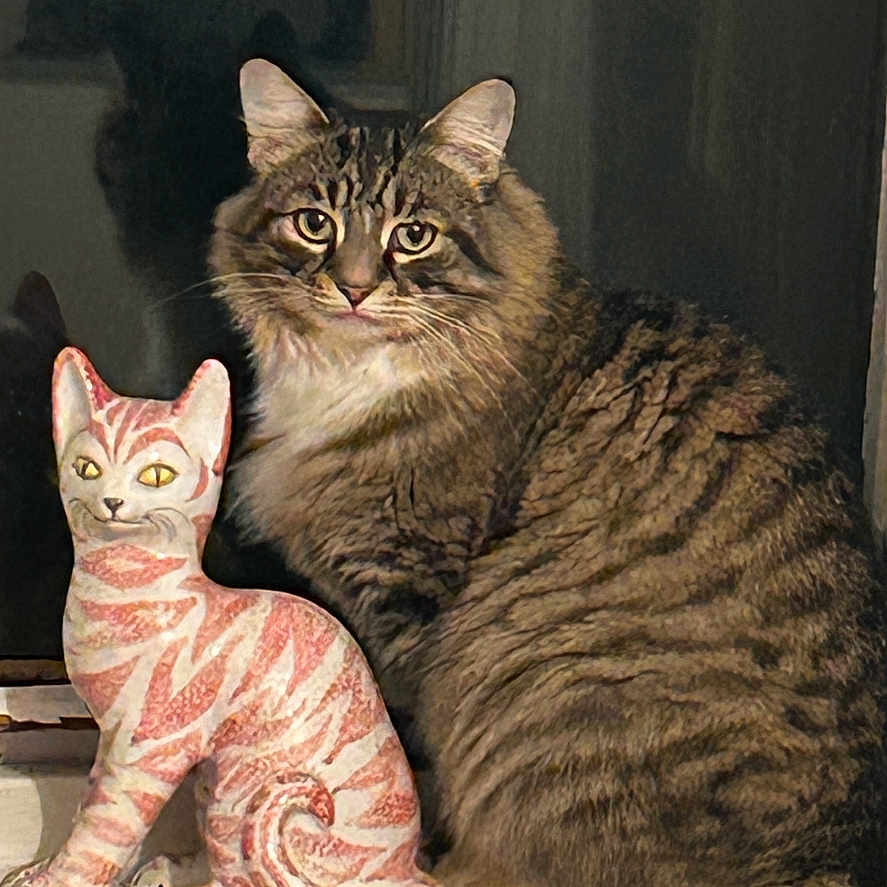 Stripy Cat is registered to the contest to win money with this photo: animal, cat, ceramic_cat, closeup, curious, cute, decor, domestic_cat, eyes, feline, fur, indoor, pet, portrait, shadow, sitting, statue, striped, tabby, windowsill
