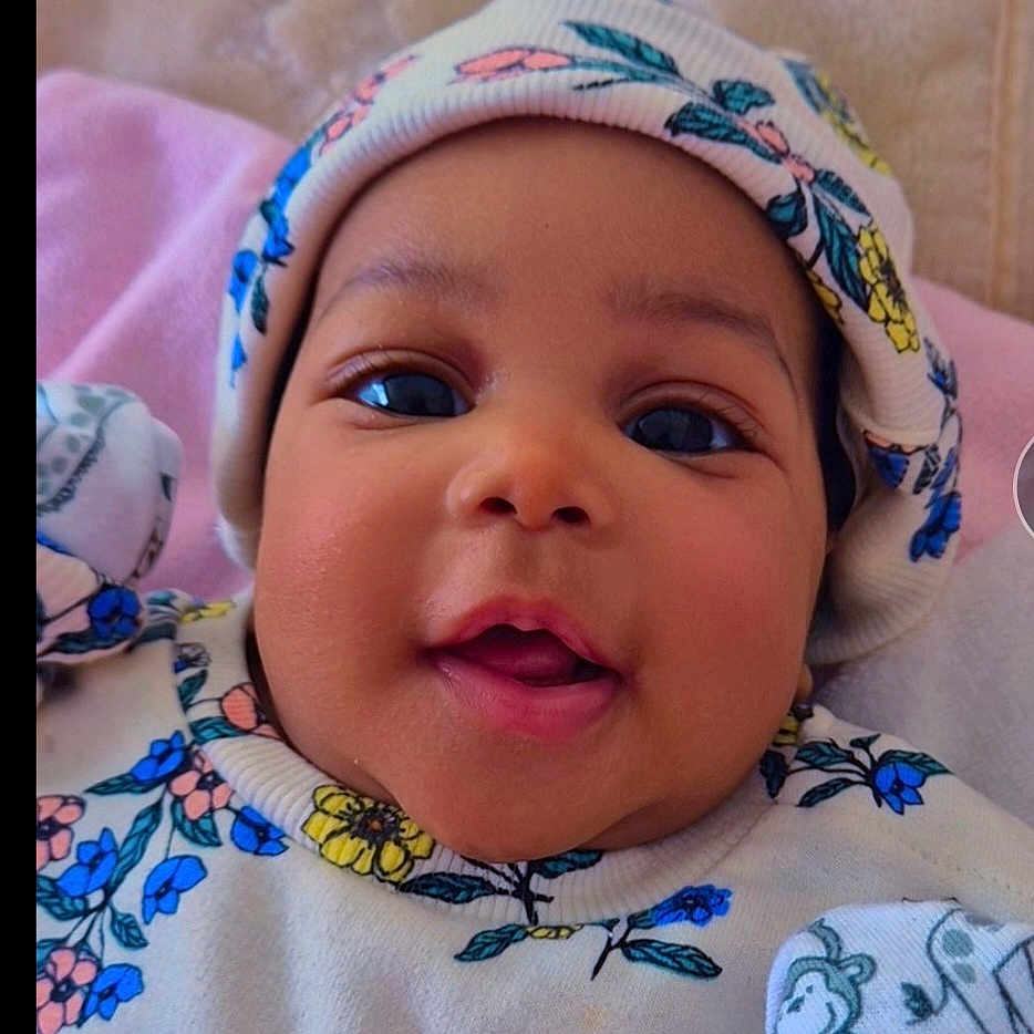 Renèe is registered to the contest to win money with this photo: baby, beanie, blanket, bodypart, bonnet, cap, clothing, face, happy, hat, head, hood, mouth, newborn, person, photography, portrait, purple, quilt, smile