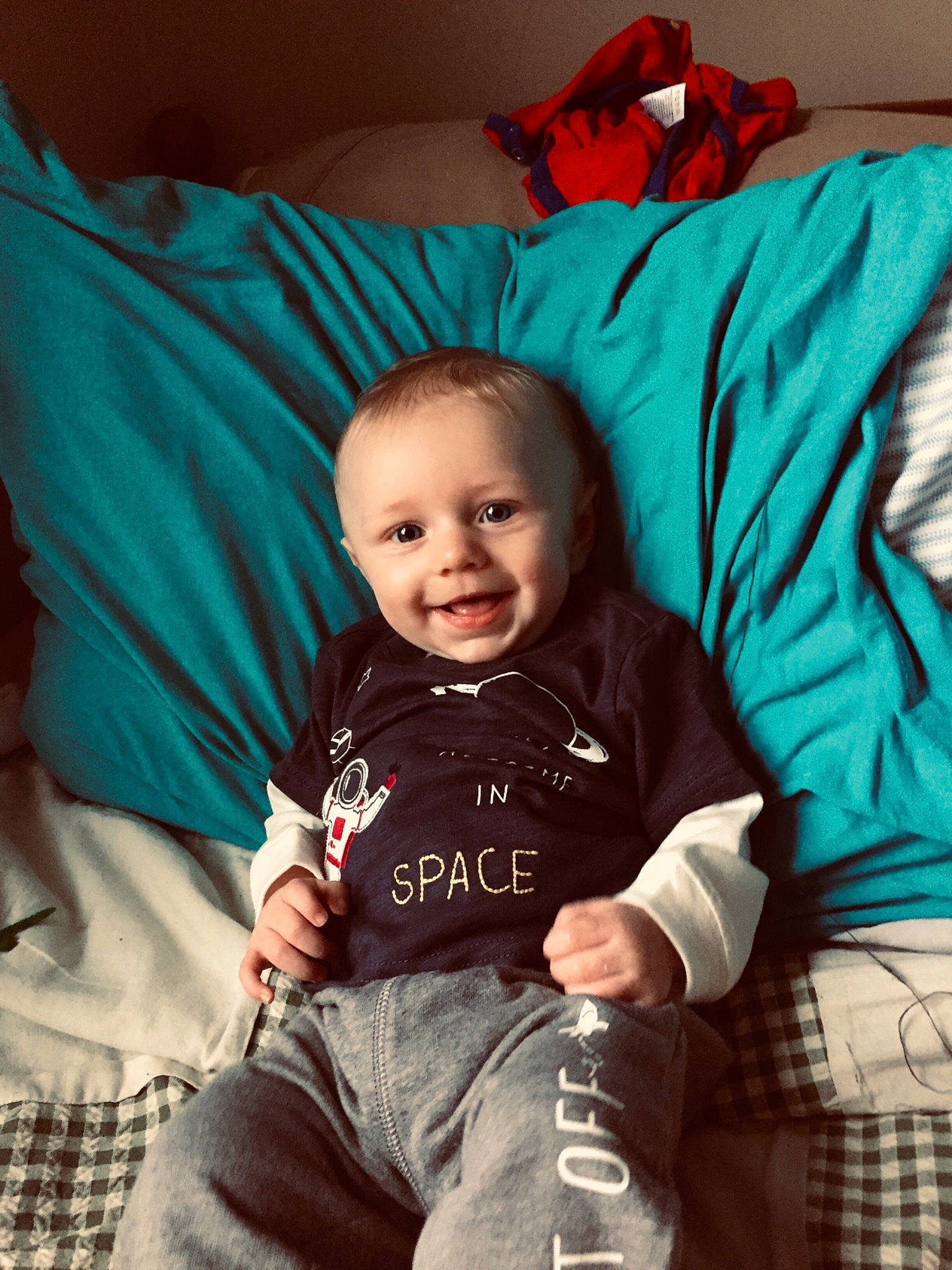 Foster is registered to the contest to win money with this photo: baby, blue, cheek, child, cool, electronic_device, eye, face, furniture, happy, head, jeans, leg, people, person, play, sitting, skin, smile, t_shirt