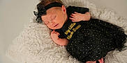 Koda is registered to the contest to win money with this photo: newborn, baby, sleeping, black_dress, headband, bow, blanket, soft_texture, infant, cute, peaceful, tiny_feet, clothing, portrait, indoors, resting, adorable, child, toddler, fashion