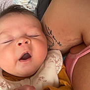 Koda joined the competition — help win amazing prizes! baby, infant, yawning, sleepy, closeup, face, hand, adult, tattoo, arm, clothing, onesie, yellow_sleeves, pink_tank_top, crib, diapers, indoor, person, skin, resting