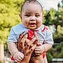 baby, child, smiling, drool, hands, outdoor, greenery, curly_hair, cute, portrait, person, white_shirt, red_clothing, happy, skin, holding, nature, daylight, infant, closeup