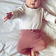 Eléa participe au concours pour gagner de l'argent avec cette photo : baby, bed, blanket, bow, child, cozy, cute, expressive_eyes, headband, indoors, infant, lying_down, pink, portrait, reaching_hand, ribbed_pants, sleepwear, small_feet, soft_texture, white_shirt