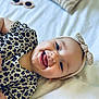 adult_hand, apparel, baby, bow, child, closeup, cute, hand, happy, headband, infant, leopard_print, lying_down, person, playful, portrait, skin, smiling, tongue_out, white_background
