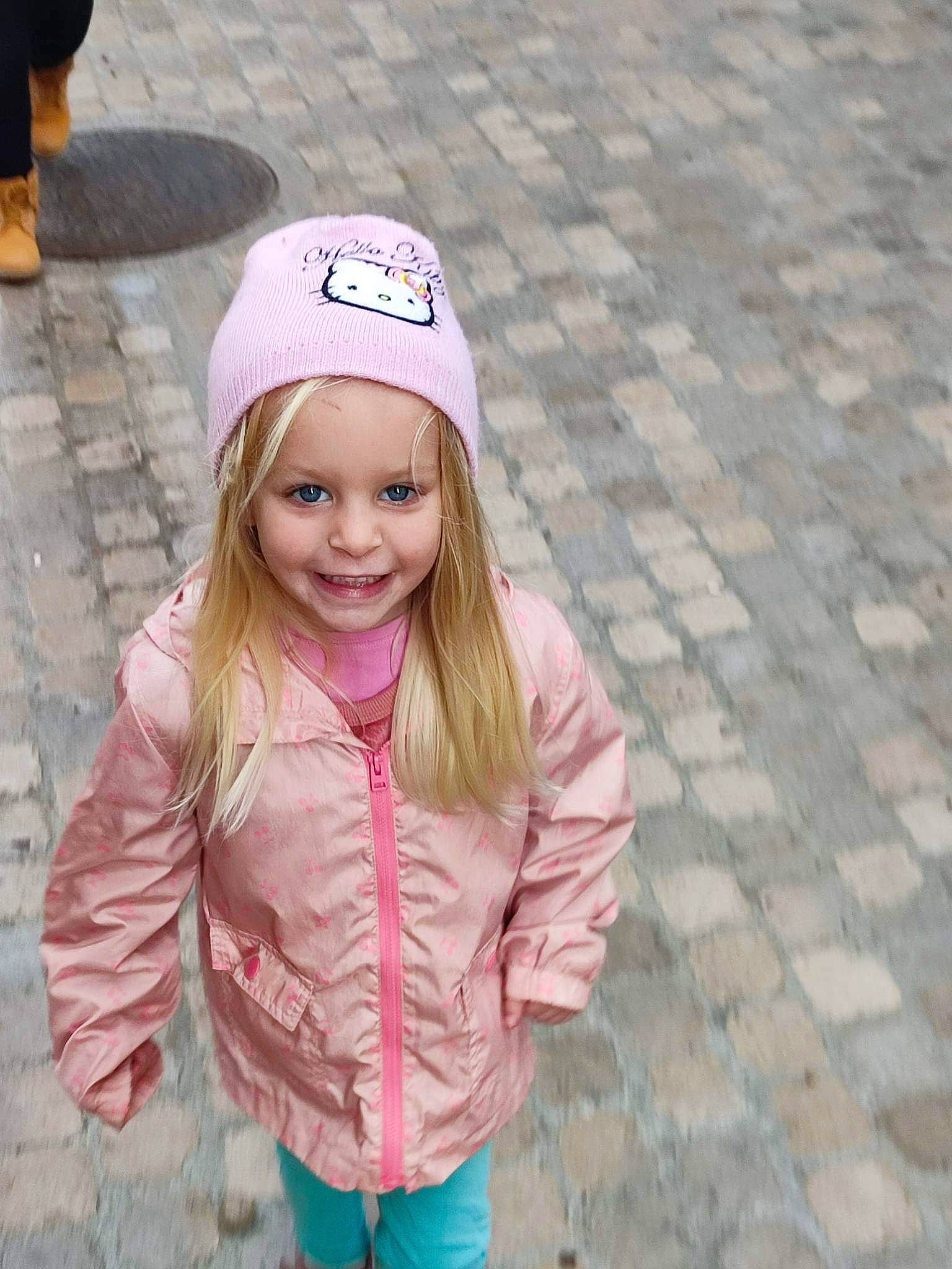 Lila a rejoint le concours — aidez-le/la à gagner de superbes lots ! asphalt, blond, cap, child, eye, face, fun, grass, hairstyle, happy, headwear, joy, leisure, lip, magenta, person, pink, road_surface, sidewalk, sleeve