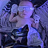 baby, sleeping, blanket, mittens, eye_mask, bed, cozy, infant, rest, soft_texture, peaceful, child, blue_light, covered, indoors, portrait, cute, young, sleepwear, comfort