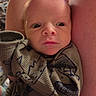 Kassian is registered to the contest to win money with this photo: arm, baby, baby_gaze, child, close_up, clothing, cozy, cute, dinosaur_print, eyes, face, indoor, infant, newborn, newborn_clothing, onesie, person, portrait, skin, soft_lighting