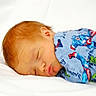 baby, sleeping, infant, red_hair, onesie, superhero, captain_america, hulk, soft, white_bed, cute, peaceful, portrait, child, face, clothing, resting, newborn, cozy, lying_down