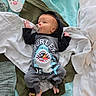 baby, infant, pacifier, clothing, onesie, shark_design, blanket, quilt, remote_control, bed, sleepwear, foot, hand, lying_down, indoors, comfort, soft_texture, child, cute, resting