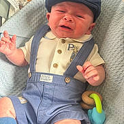 Reggie joined the competition — help win amazing prizes! baby, blanket, blue, cap, closeup, clothing, crying, cute, expression, face, hand, indoors, infant, overalls, pacifier, peter_rabbit, sitting, skin, textile, toy