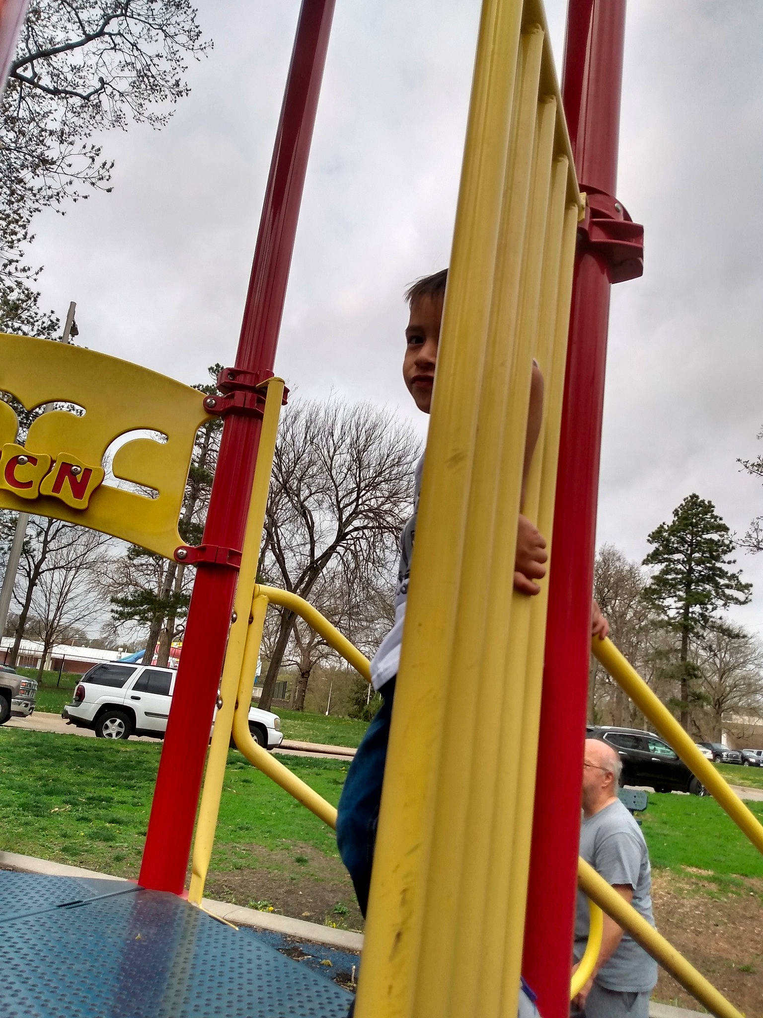 Connor is registered to the contest to win money with this photo: car, chute, city, cloud, fun, grass, leisure, outdoor_play_equipment, person, plant, playground, playground_slide, pole, recreation, shade, sky, tints_and_shades, tire, tree, wheel