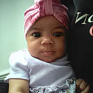 Nature is registered to the contest to win money with this photo: baby, child, infant, headband, pink, dress, floral, person, portrait, closeup, cute, indoors, clothing, face, eyes, hand, sitting, white_shirt, black_shirt, background