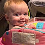 Annabella is registered to the contest to win money with this photo: baby, child, smile, face, indoor, walker, toy, colorful, cheeky, hair, couch, fabric, warning_label, infant, playtime, happy, cute, person, soft, seat