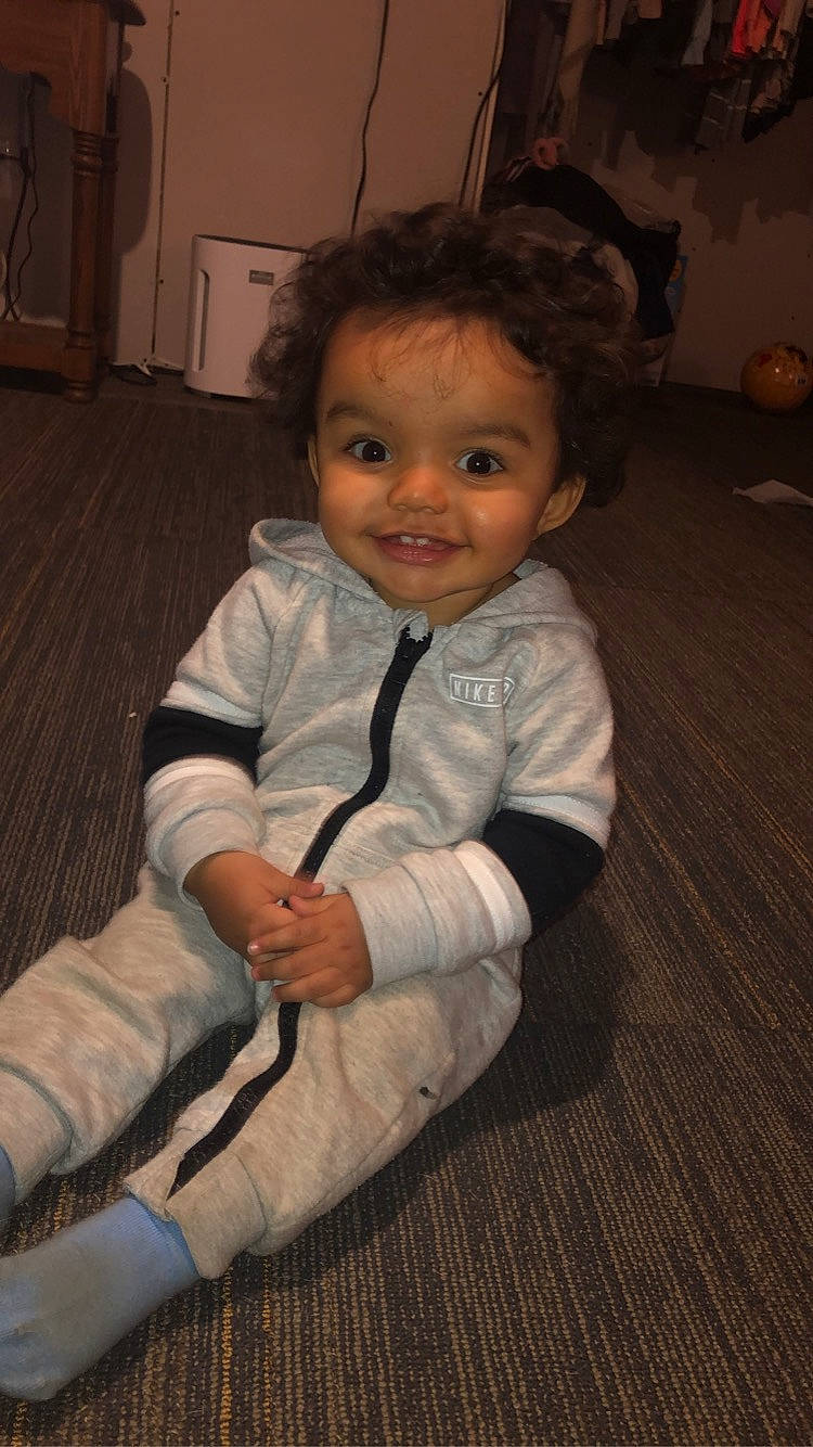 Mason is registered to the contest to win money with this photo: baby, baby_toddler_clothing, brown, cheek, child, comfort, flash_photography, floor, flooring, happy, hardwood, head, houseplant, joy, nose, person, sitting, skin, sleeve, smile