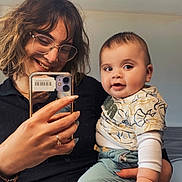 Rayane a rejoint le concours — aidez-le/la à gagner de superbes lots ! woman, baby, mirror, selfie, glasses, smile, indoor, clothing, holding, phone, child, casual, happy, person, portrait, home, reflection, face, long_hair, short_hair