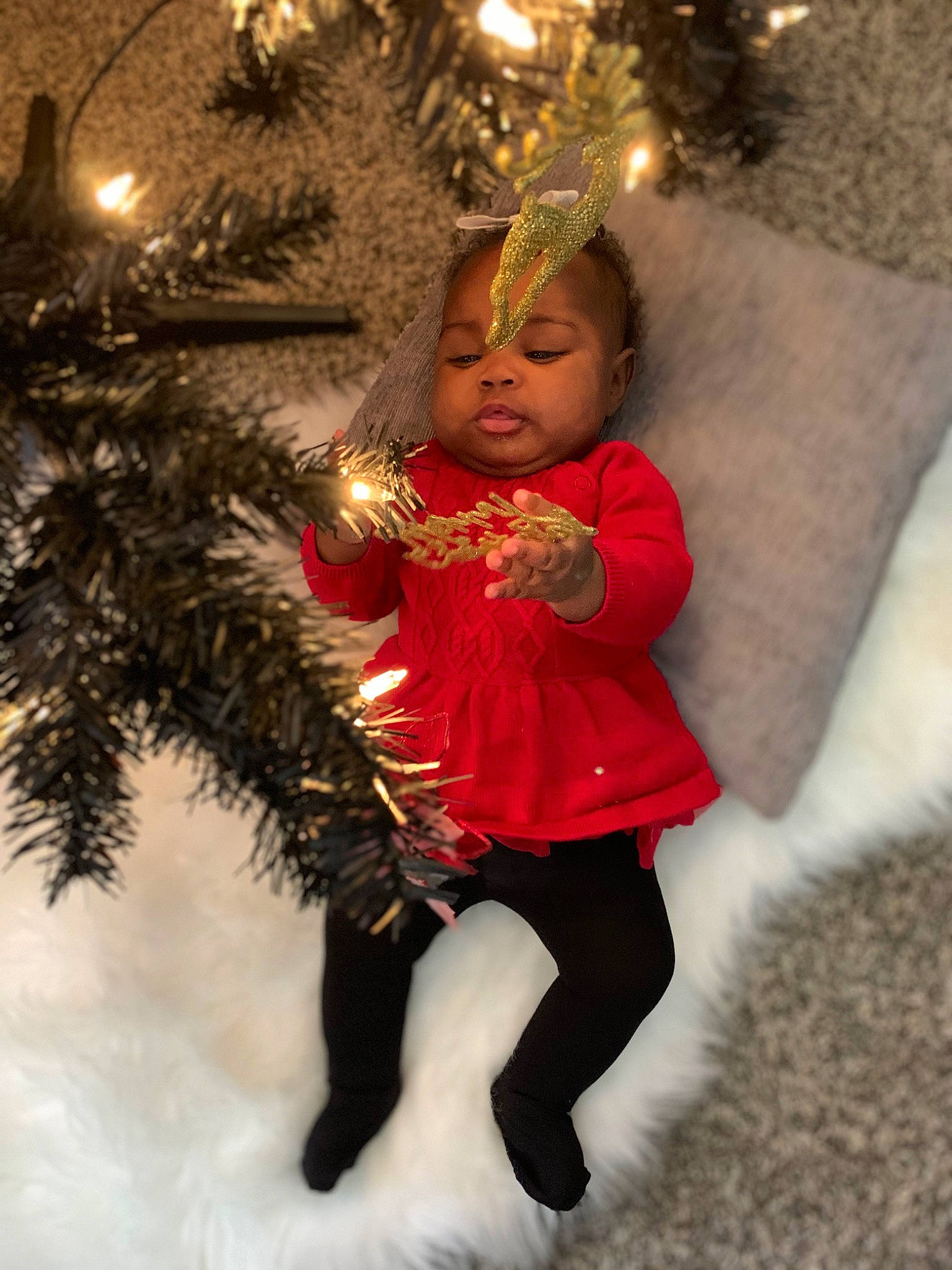 Jadé is registered to the contest to win money with this photo: blond, child, christmas, christmas_decoration, christmas_ornament, christmas_tree, event, face, facial_expression, fun, fur, happy, holiday, holiday_ornament, human_body, human_leg, ornament, person, thigh, toddler