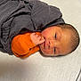 Jaxon joined the competition — help win amazing prizes! baby, bed, blanket, child, cute, face, hand, indoors, infant, lying_down, newborn, newborn_baby, orange_clothing, peaceful, portrait, skin, sleepy, small, soft_surface, swaddled