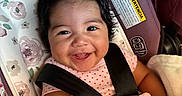 Valerie is registered to the contest to win money with this photo: baby, smiling, car_seat, pink_bow, blanket, child, infant, happy, cute, face, portrait, clothing, seatbelt, indoors, closeup, person, pink, soft, comfort, baby_girl