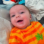 Jacob joined the competition — help win amazing prizes! baby, child, smiling, orange_clothing, striped_clothing, carrot_design, infant, face, happy, lying_down, blanket, toy, indoors, cute, close_up, person, soft_surface, bright_colors, expression, joyful