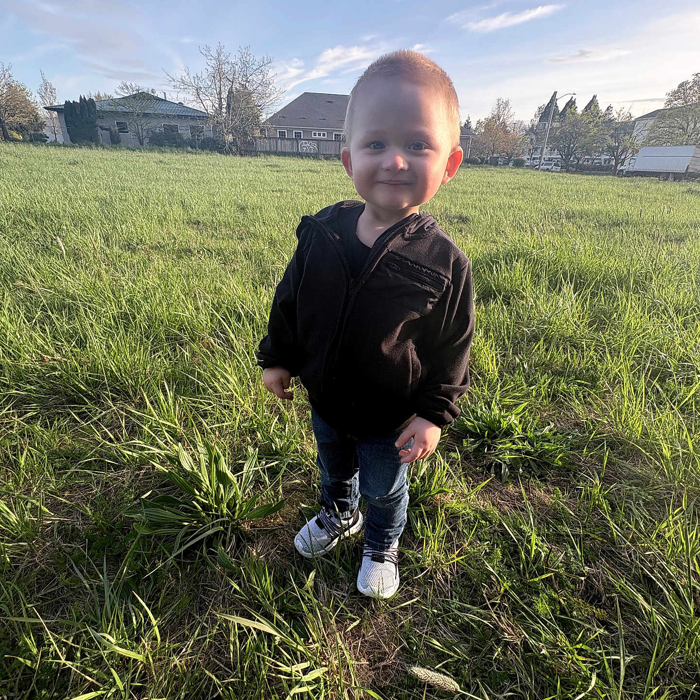Jaiden Slayer is registered to the contest to win money with this photo: casual_clothing, child, cute, daylight, field, grass, greenery, happy, jacket, nature, outdoor, person, portrait, sky, smile, sneakers, standing, sunlight, toddler, young_child