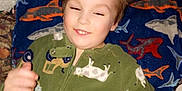 Leonardo joined the competition — help win amazing prizes! bed, blanket, child, comfort, cows, cozy, face, green_onesie, hair_spiky, happy, indoor, pajamas, person, pillow, relaxed, shark_pattern, sleepwear, smiling, tractors, young_child